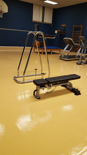 A gym setup featuring a weight bench and other exercise equipment.