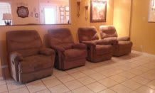 A cozy living room setup featuring multiple recliners arranged in a row.