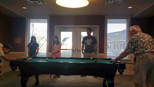 A group of friends enjoying a game around a pool table.
