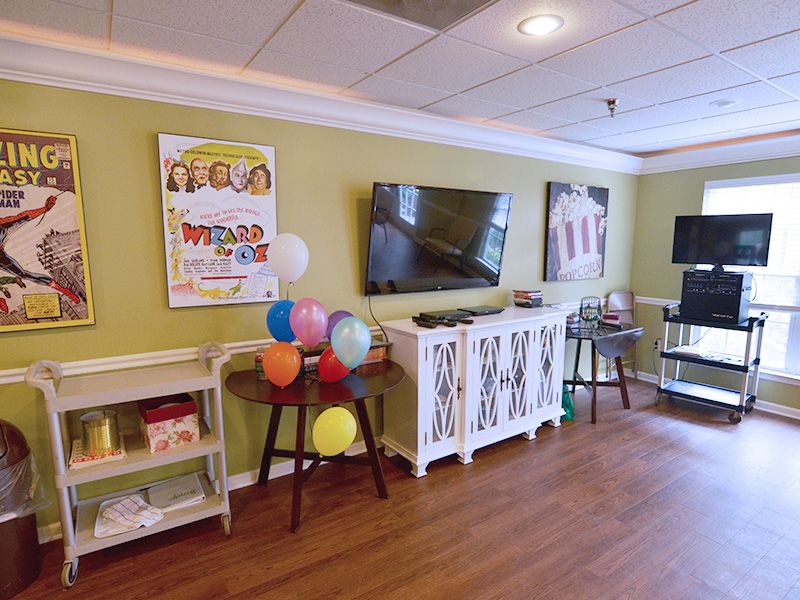 A brightly decorated living room with balloons and a television.