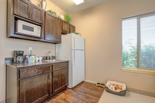A cozy kitchen featuring modern wood cabinets, a white refrigerator, and ample natural light.