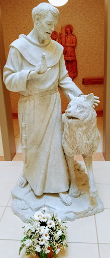 A marble statue depicting a figure standing beside a wolf, showcasing intricate details and craftsmanship.