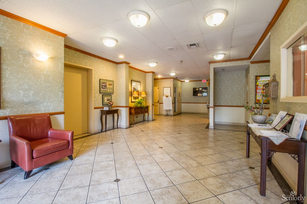 A well-lit hotel lobby with comfortable seating and an elevator.