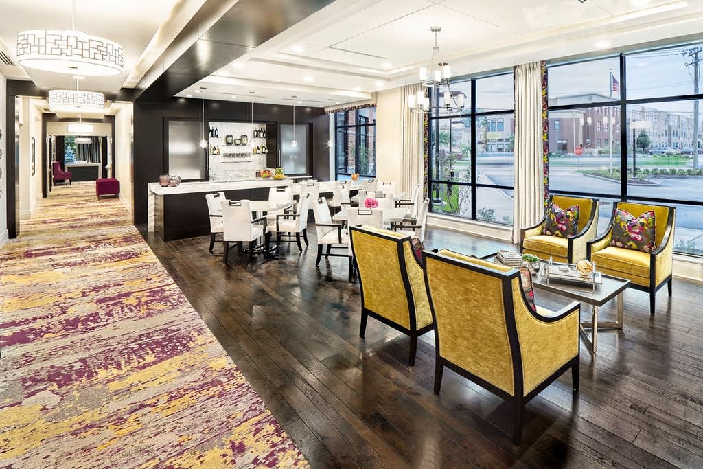 A modern and luxurious open-plan living and kitchen area with elegant furnishings and hardwood floors.