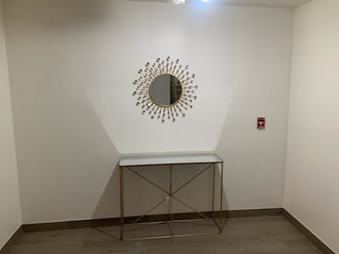 A minimalist hallway with a decorative mirror and a console table.
