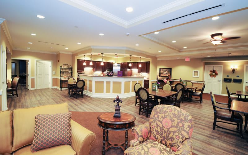 A cozy lounge area with comfortable seating and a central dining section, beautifully lit.
