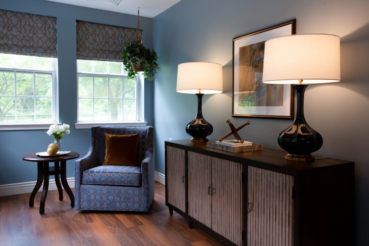 Cozy living room with armchair, sideboard, and elegant lighting.
