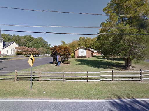 A quiet residential neighborhood featuring a house surrounded by trees and a well-maintained lawn.