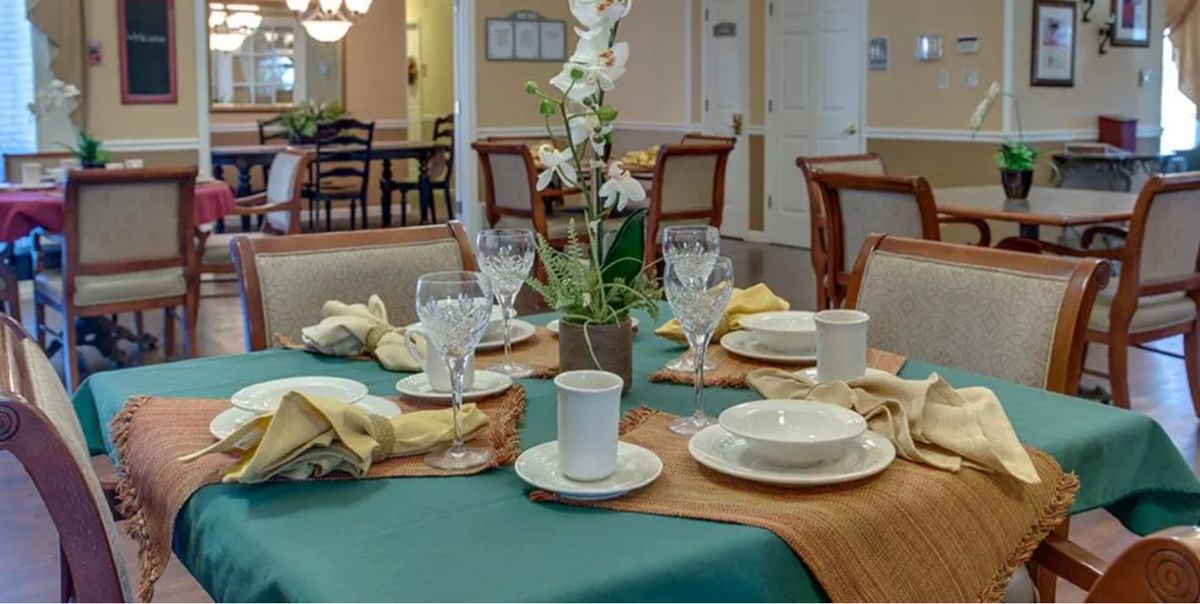 A beautifully set dining table with a floral centerpiece and elegant tableware.