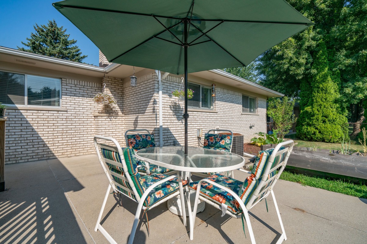 A cozy patio setup with a table, chairs, and an umbrella.