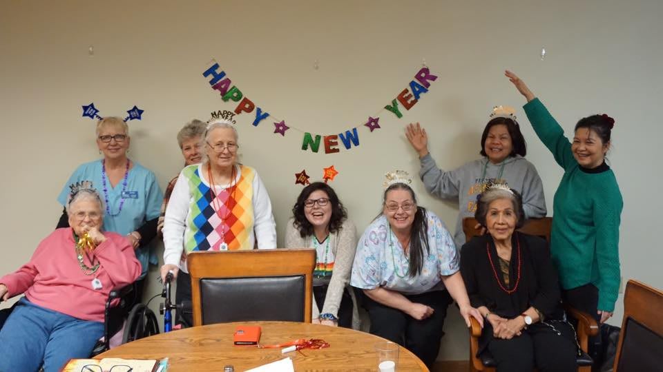 A group of people celebrating New Year's with festive decorations and smiles.