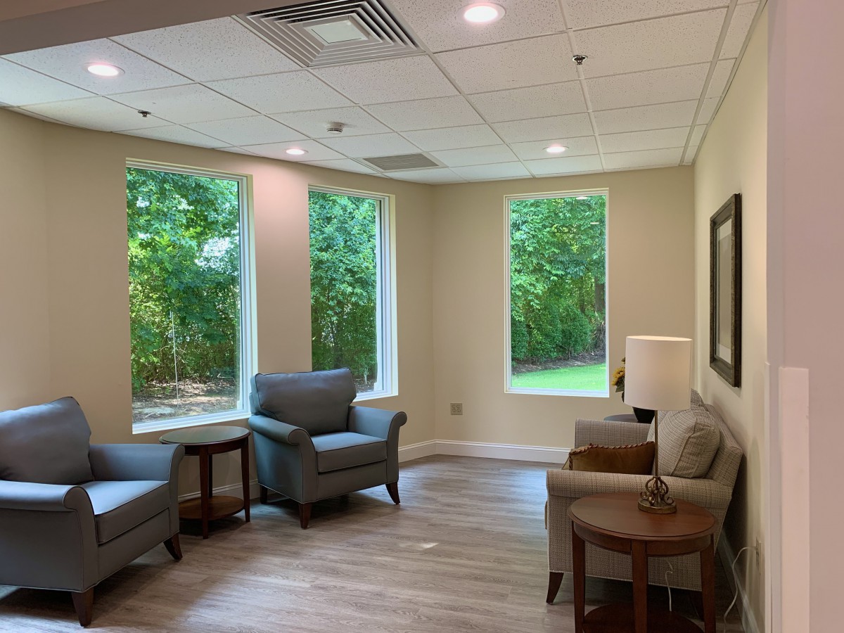 A cozy living room with comfortable chairs and large windows letting in natural light.