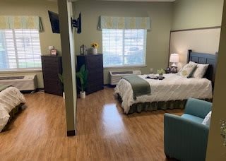 A well-lit bedroom with wooden flooring and modern decor.