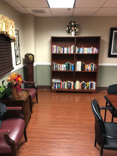A cozy reading nook featuring a bookshelf filled with books, comfortable seating, and warm lighting.