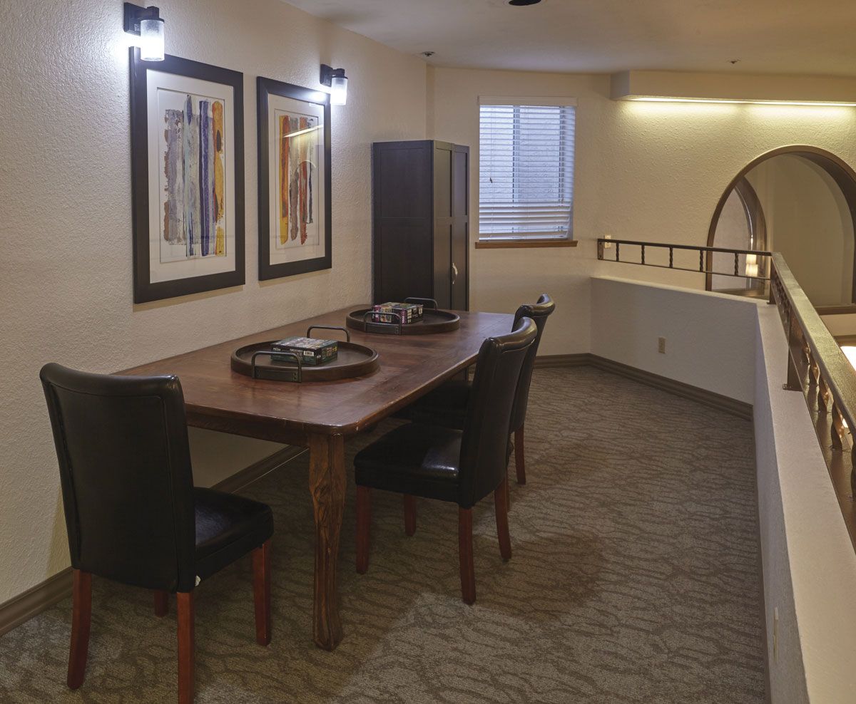 A cozy dining area with a wooden table, chairs, and artistic wall decorations.