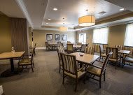 A well-furnished dining room with tables and chairs arranged neatly under soft lighting.