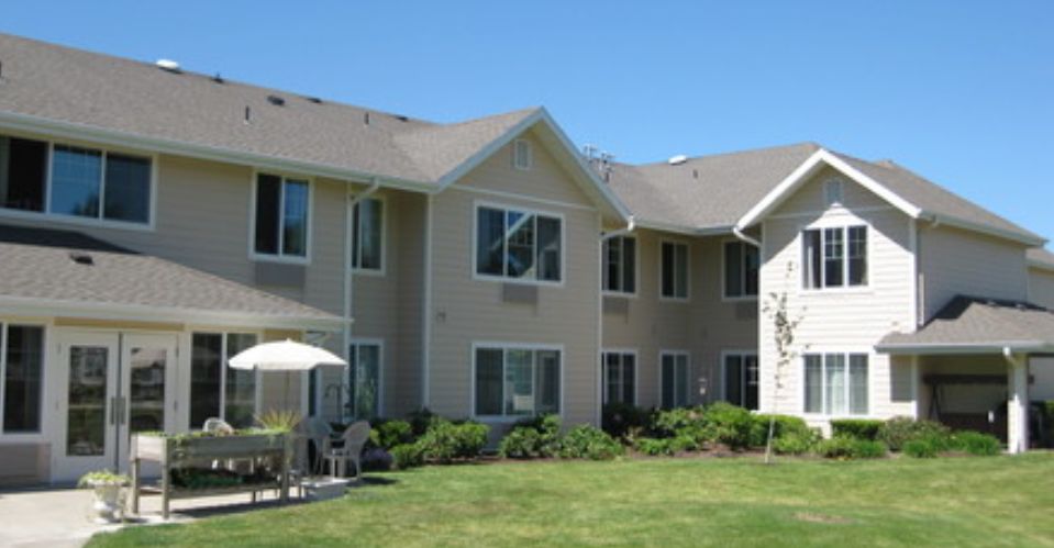 A view of a residential building with well-maintained lawn and windows.