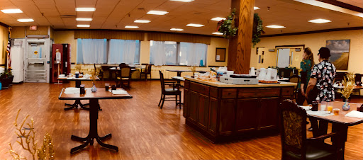 A spacious dining area featuring wooden furniture, ample natural light from large windows, and a warm ambiance.