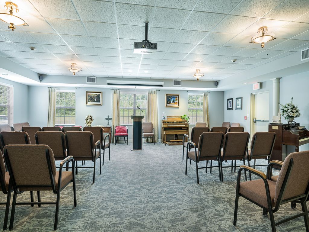 An interior view of a small chapel with seating arranged around a central podium.