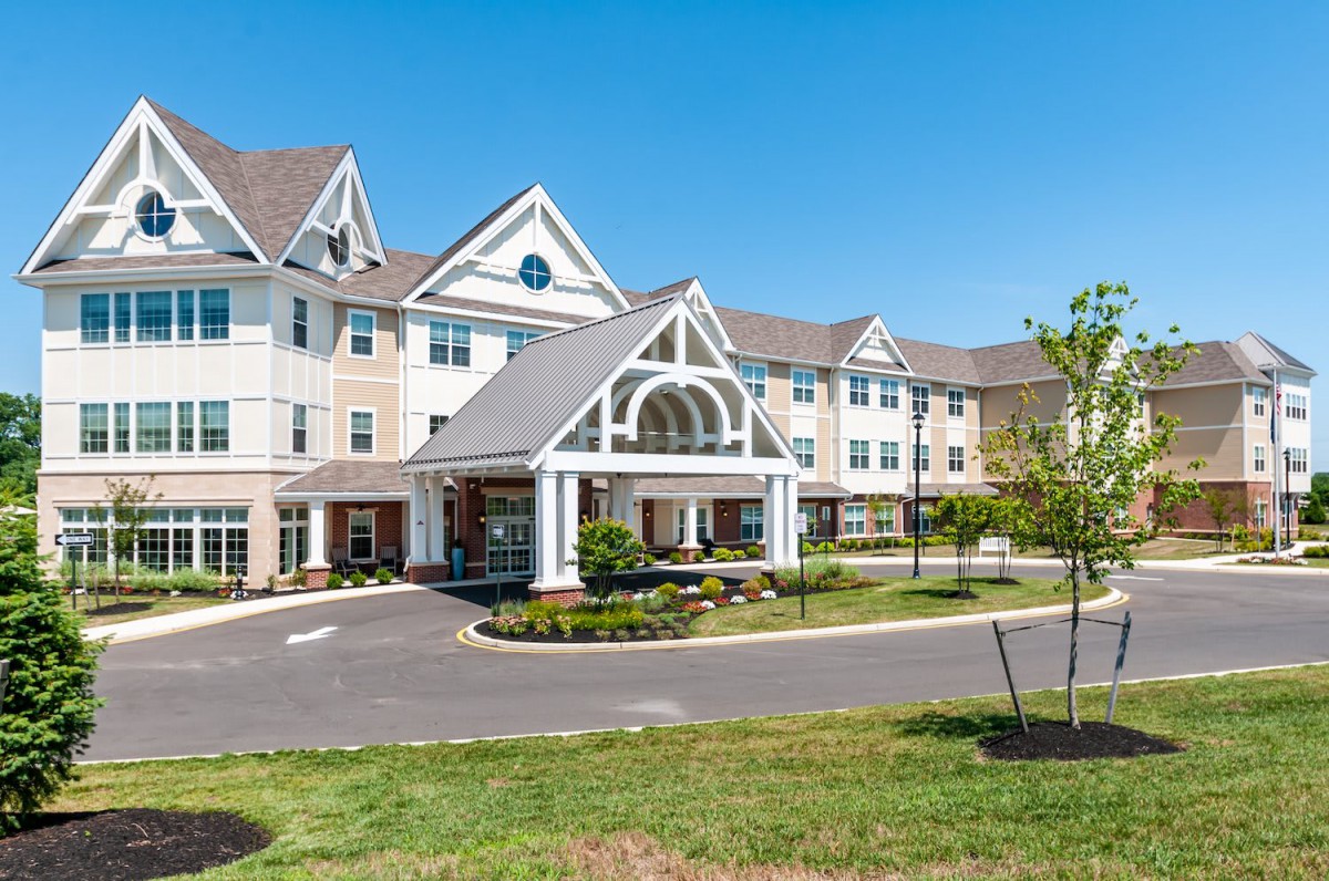 A picturesque view of a large residential building under a clear blue sky.