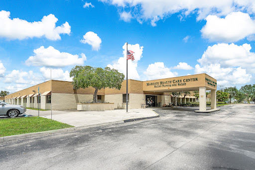 A medical center featuring a welcoming exterior and an American flag, surrounded by landscaped areas.