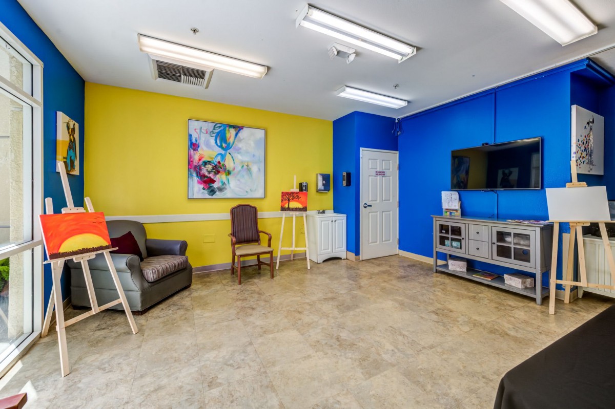 A vibrant waiting room with colorful walls, featuring a television and seating area.