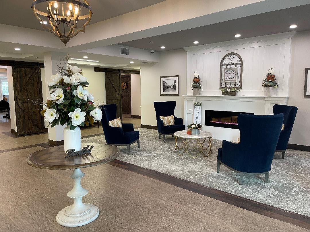 A modern and elegant lobby with comfortable seating, fireplace, and decorative elements.
