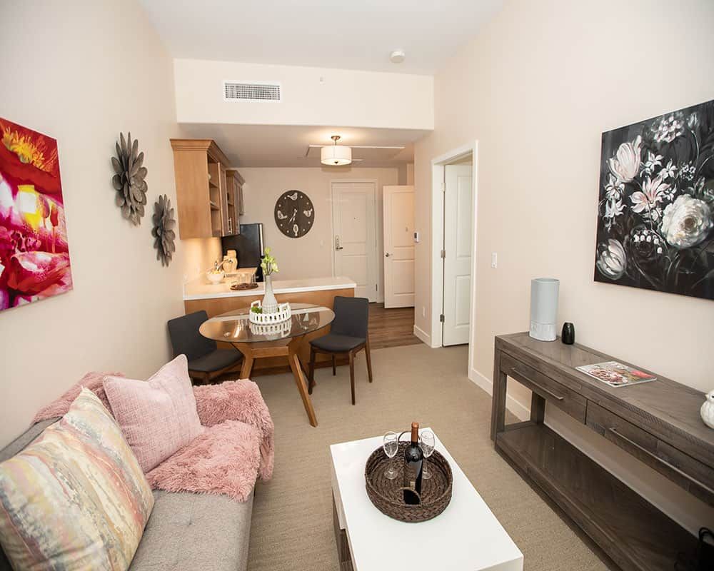 A cozy apartment living room with modern decor and an adjoining dining area.