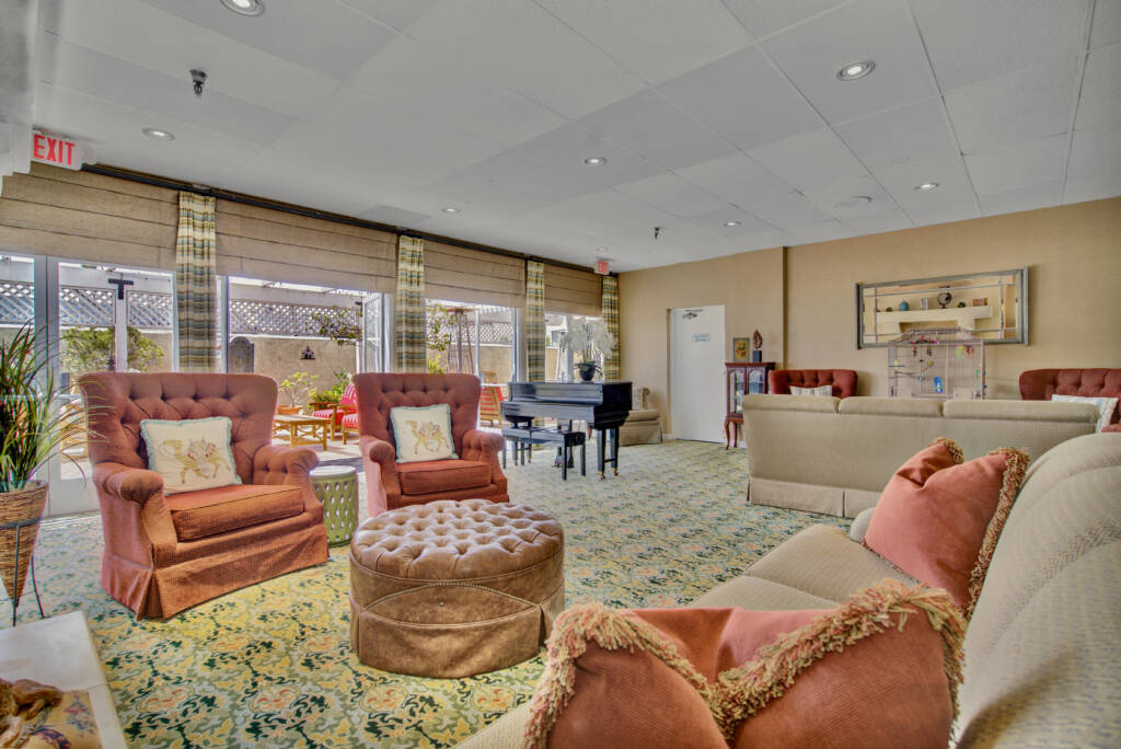 A cozy living room with ample seating and a piano.