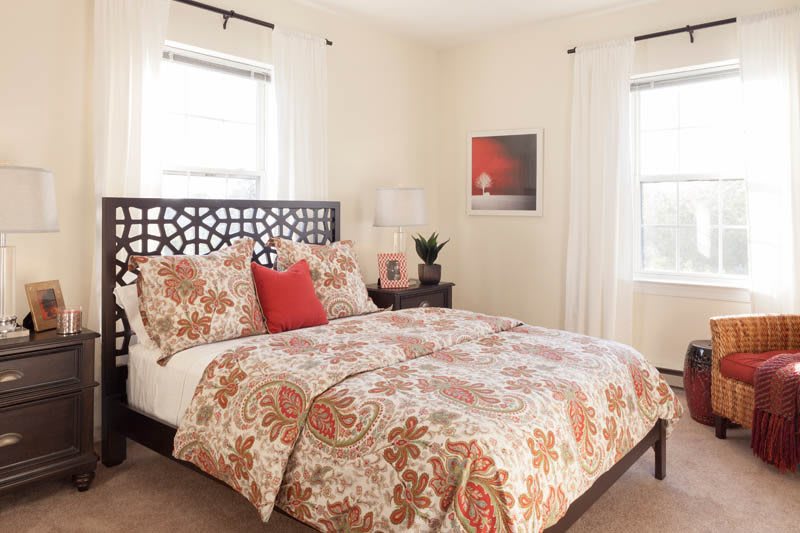 A cozy bedroom featuring floral patterned bedding and elegant decor.