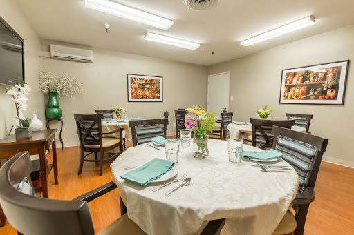 A cozy dining room setup featuring elegantly arranged tables with floral centerpieces.