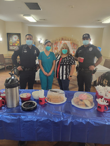 Community members and police officers come together for a celebration, enjoying snacks and refreshments.