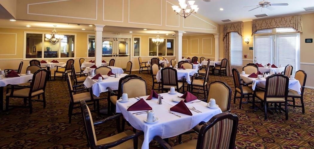 An elegant dining room with neatly set tables and chairs.