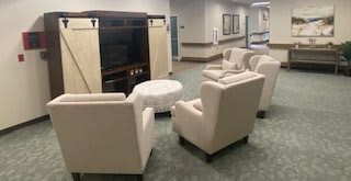 A cozy seating area with armchairs arranged around a table and a television cabinet.