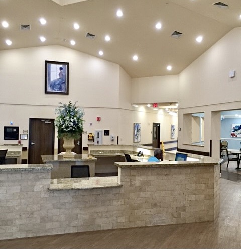 A spacious and modern reception area with elegant lighting and floral decor.