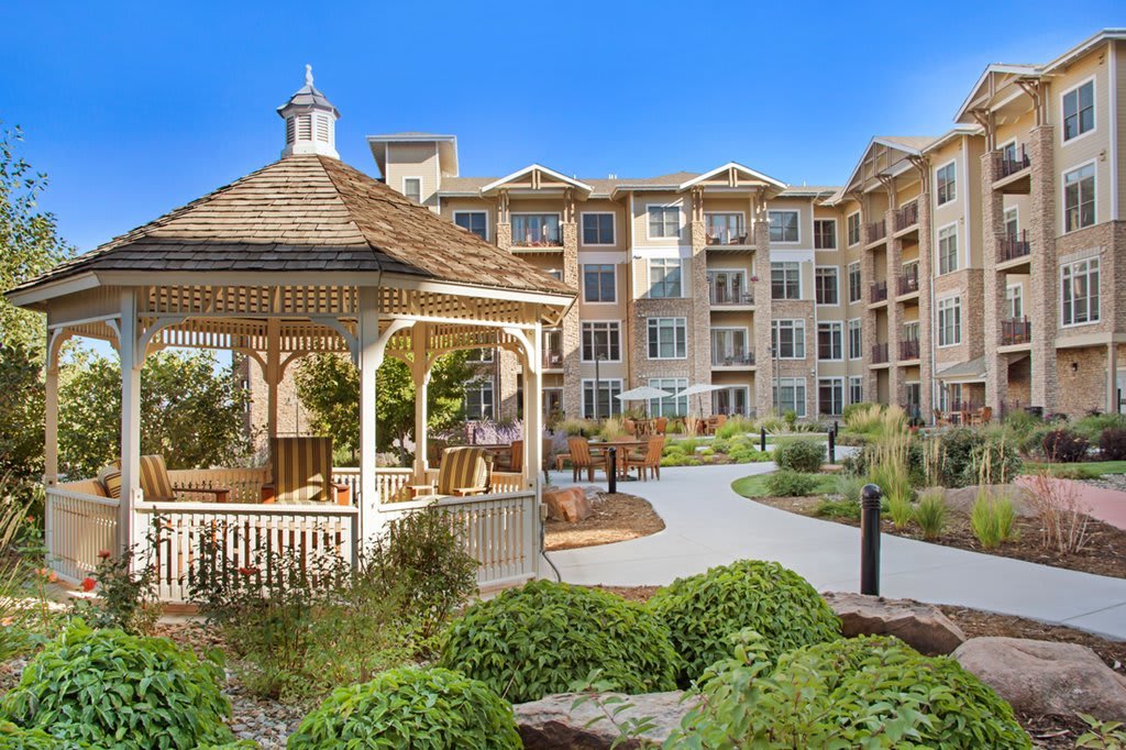 A well-landscaped apartment complex featuring a charming gazebo and a winding pathway.