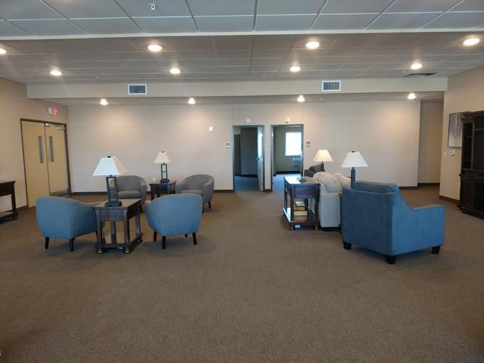 A spacious lounge area with comfortable seating and tables.
