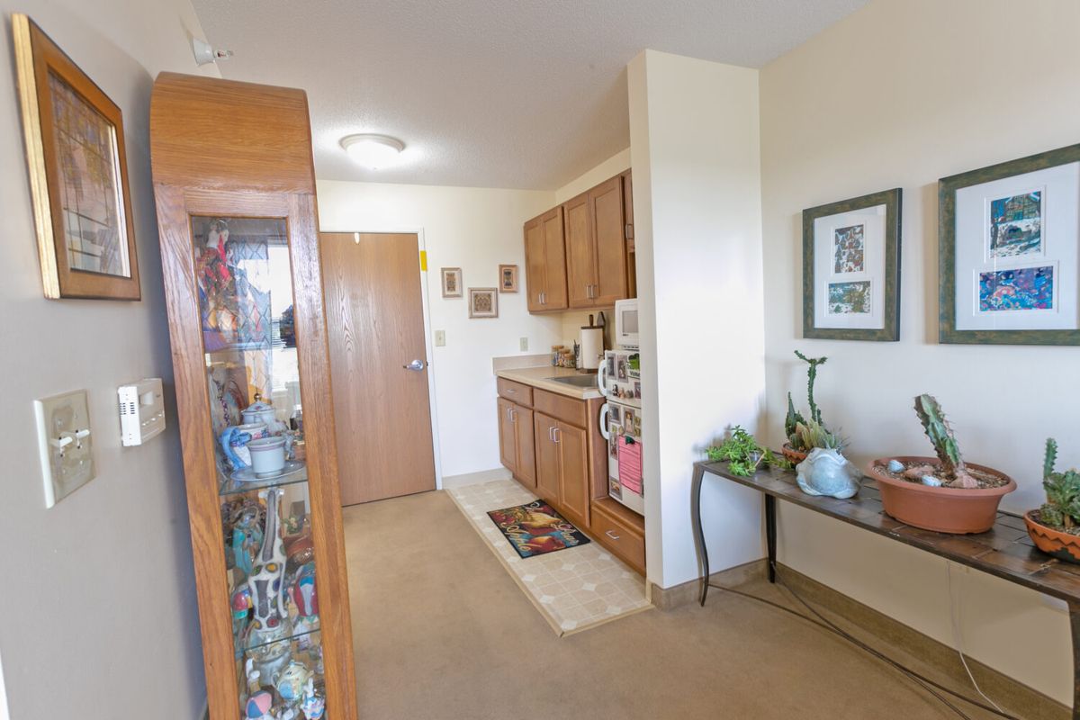 A cozy kitchen area in an apartment with wooden cabinets and decorative elements.