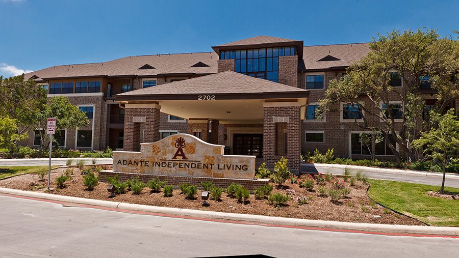 Entrance to a residential building with prominent signage and landscaping.