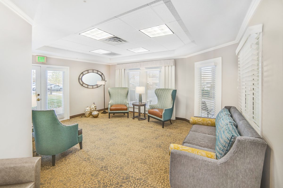 A well-lit living room with armchairs, a sofa, and a coffee table.