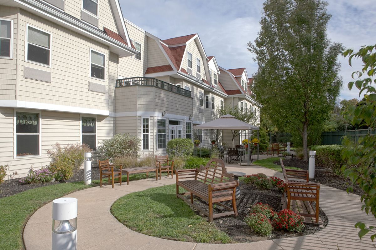 A scenic view of a residential building with outdoor seating and landscaped gardens.