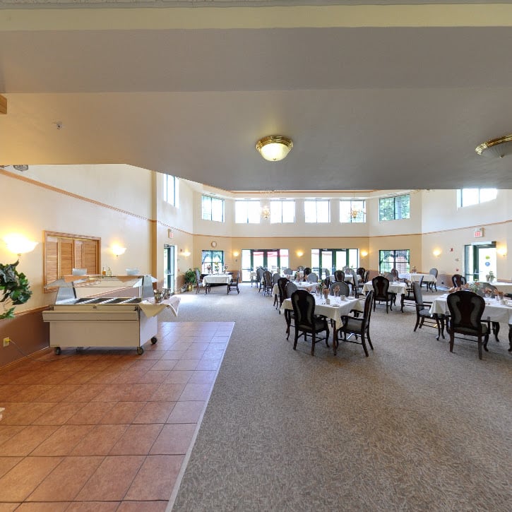 A spacious dining room with neatly arranged tables and a buffet area.
