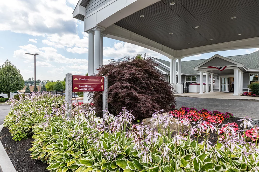 Beautifully landscaped entrance with colorful flowers and a welcoming building.