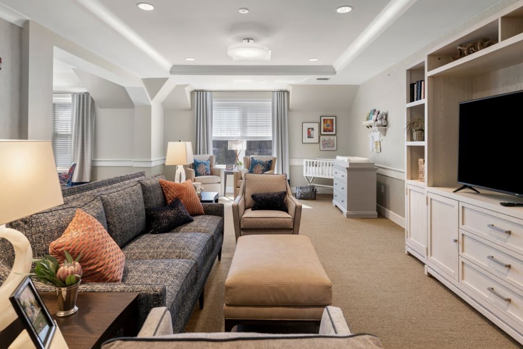 A modern living room with comfortable seating, featuring a cozy sofa and an adjacent home office space.