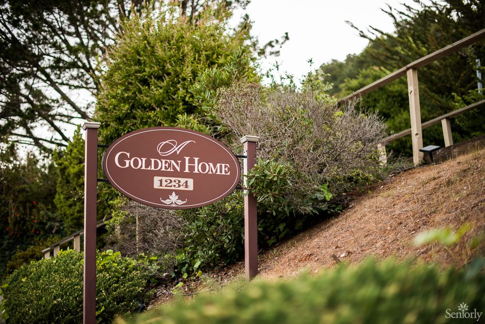 A sign for a place called 'Golden Home' surrounded by greenery.