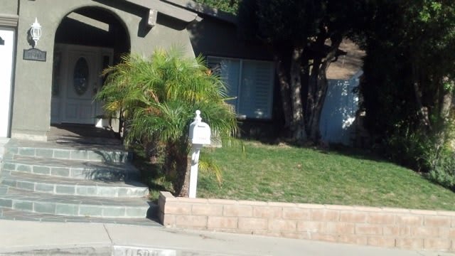 A suburban house with a mailbox and a grassy front yard.
