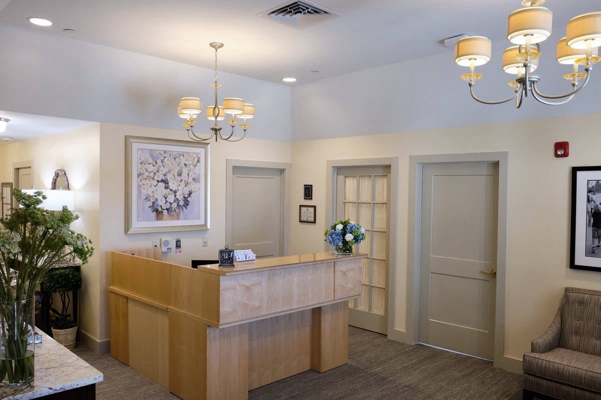 A reception desk in an office setting with warm lighting and neutral decor.