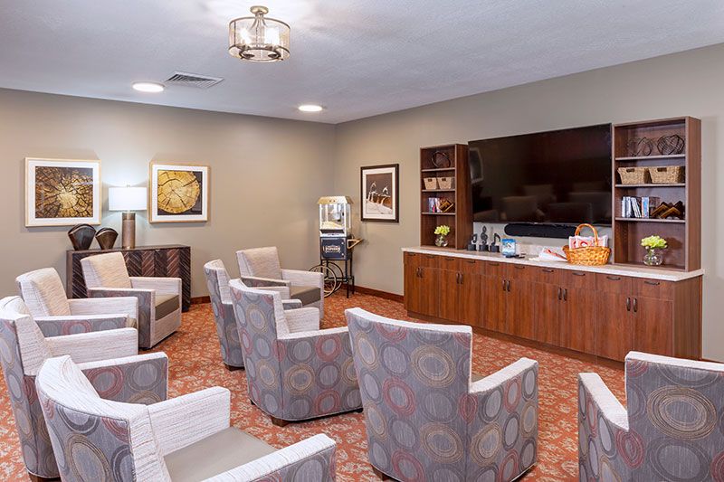 A comfortable waiting room with chairs arranged in a circle, a television, and a coffee station.