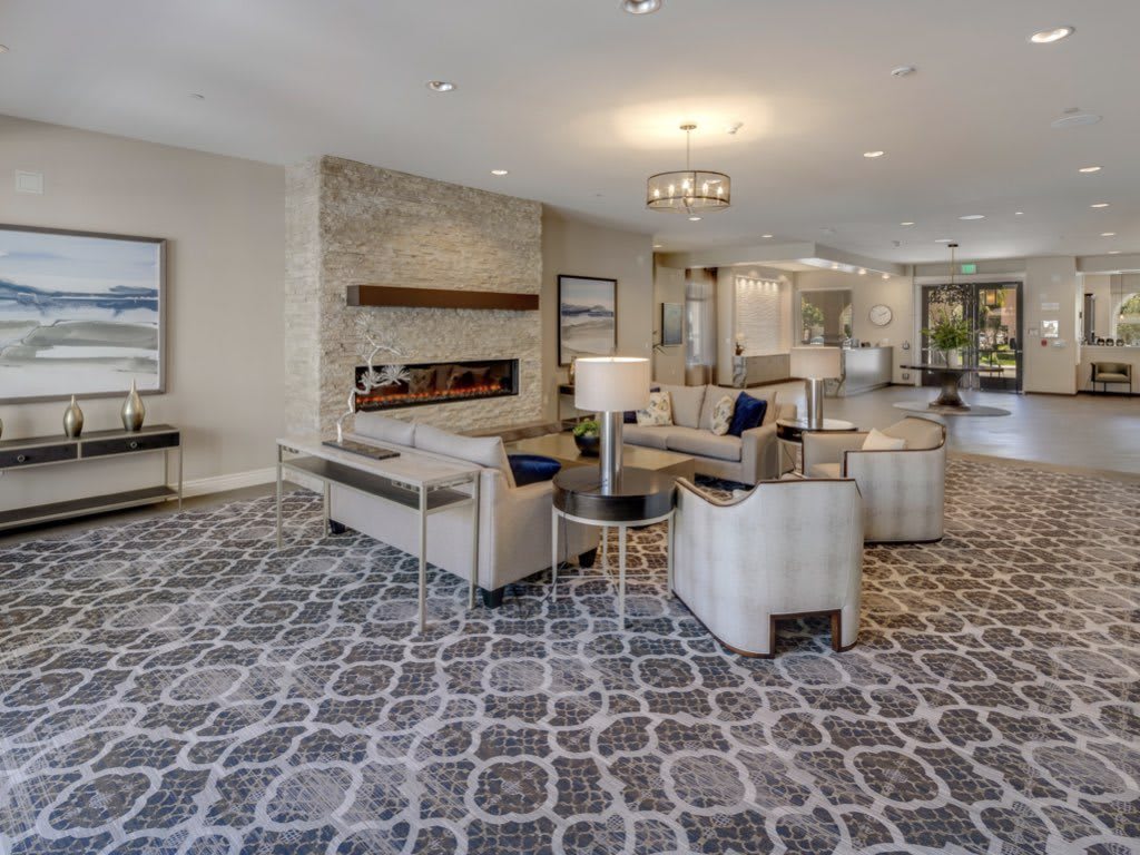 A modern and luxurious lobby featuring elegant seating, a stylish chandelier, and contemporary decor.