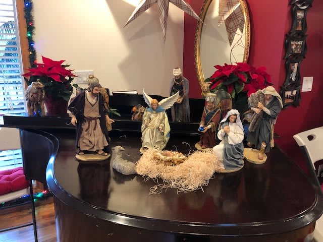 A beautifully arranged nativity scene adorned with poinsettias on a tabletop.